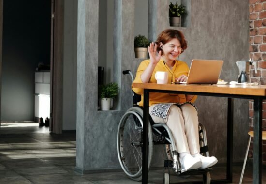 Women in wheelchair waving at computer screen